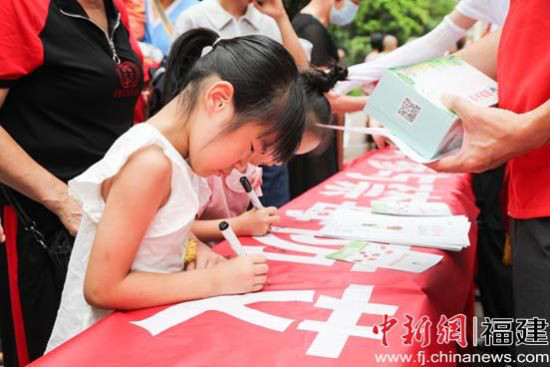 社区居民在活动条幅上签名 社区居民在活动条幅上签名